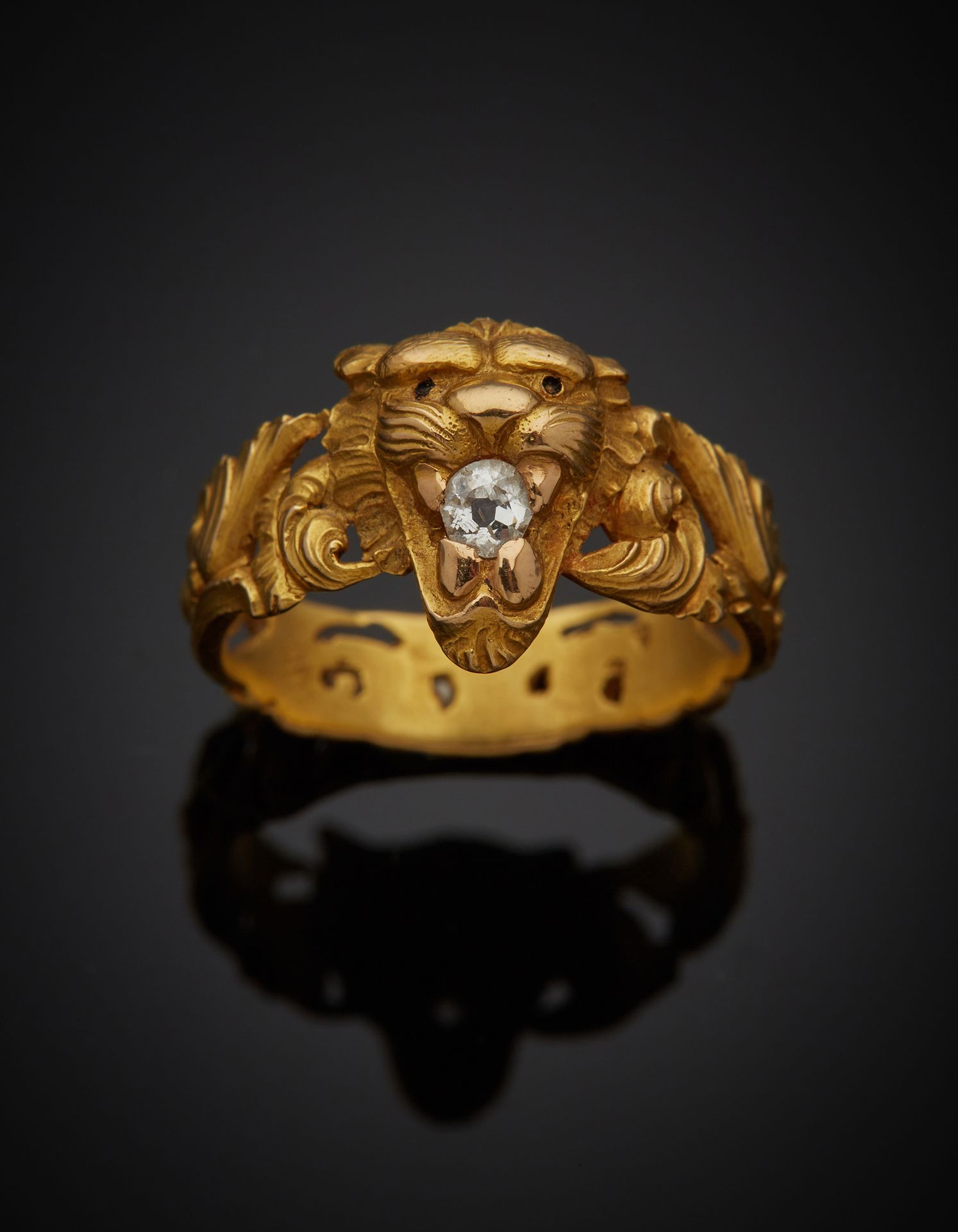 Null 一枚18K黄金750‰的戒指，装饰着一个狮子头，嘴里叼着一颗老式切割钻石，戒指上完全镂空的刺桐叶。这块石头是有种子的。

手指大小56，毛重6g