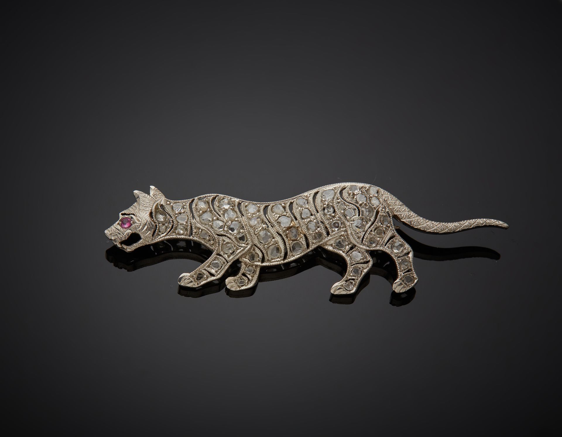 Null 一枚850‰的铂金胸针，为猫科动物的形状，有镂空的装饰，镶有玫瑰切割的钻石和一颗红色的石头。石头上镶嵌着种子。

L. 5 cm 毛重 4.70 g