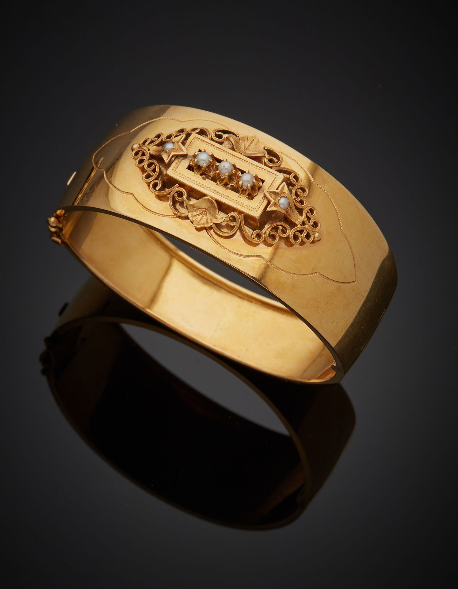 Null 一个18K黄金750‰的手镯，上面有一个卷轴设计，并有可能是精美的半颗珍珠（未测试）。棘轮扣，带安全八字。穿到珍珠上。

内径约6厘米 毛重41.40&hellip;