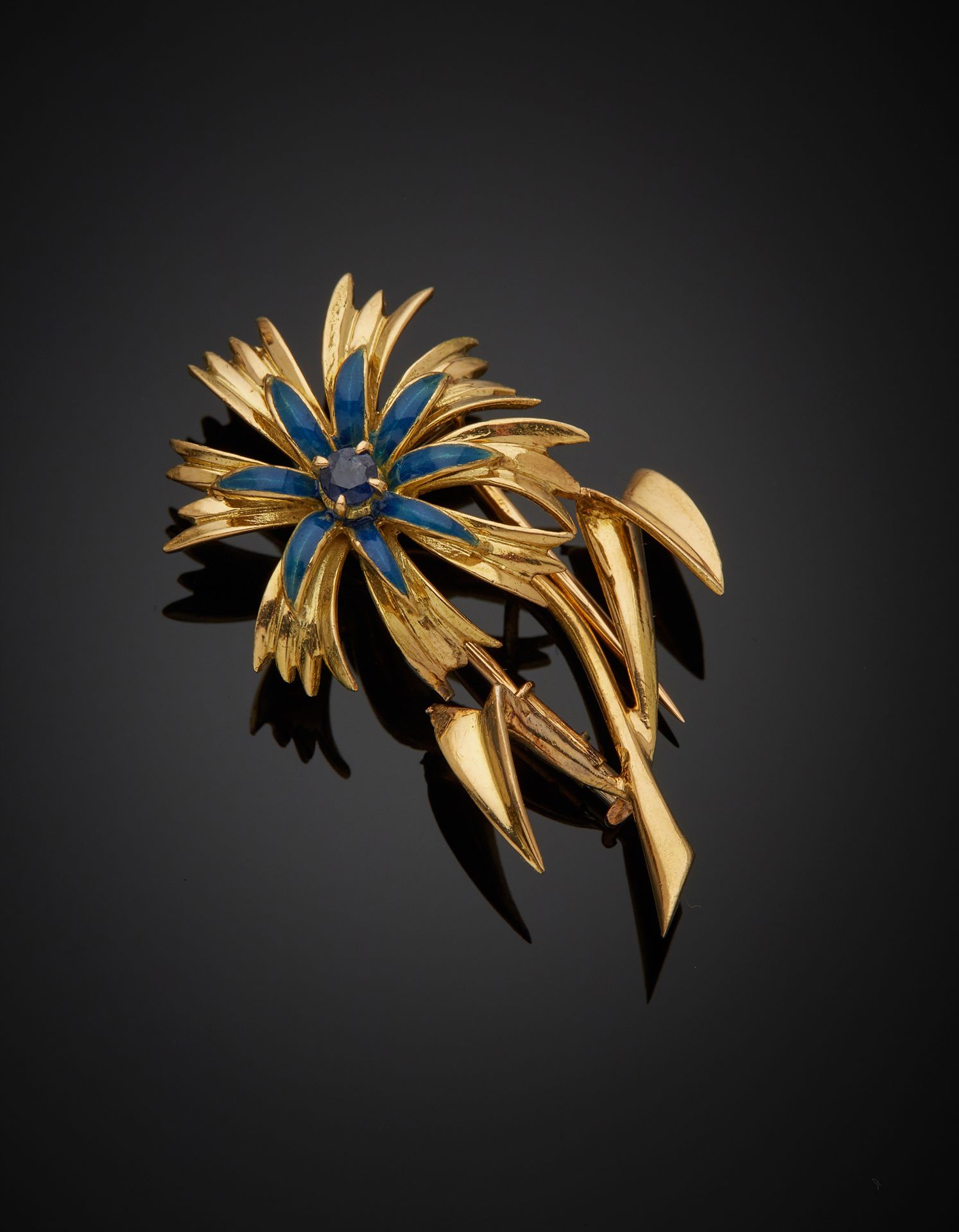 Null 一个18K黄金750‰的领夹，采用了矢车菊的形式，中心镶嵌了一颗圆形蓝宝石。法国的工作。使用的痕迹

H.4厘米 毛重6.90克