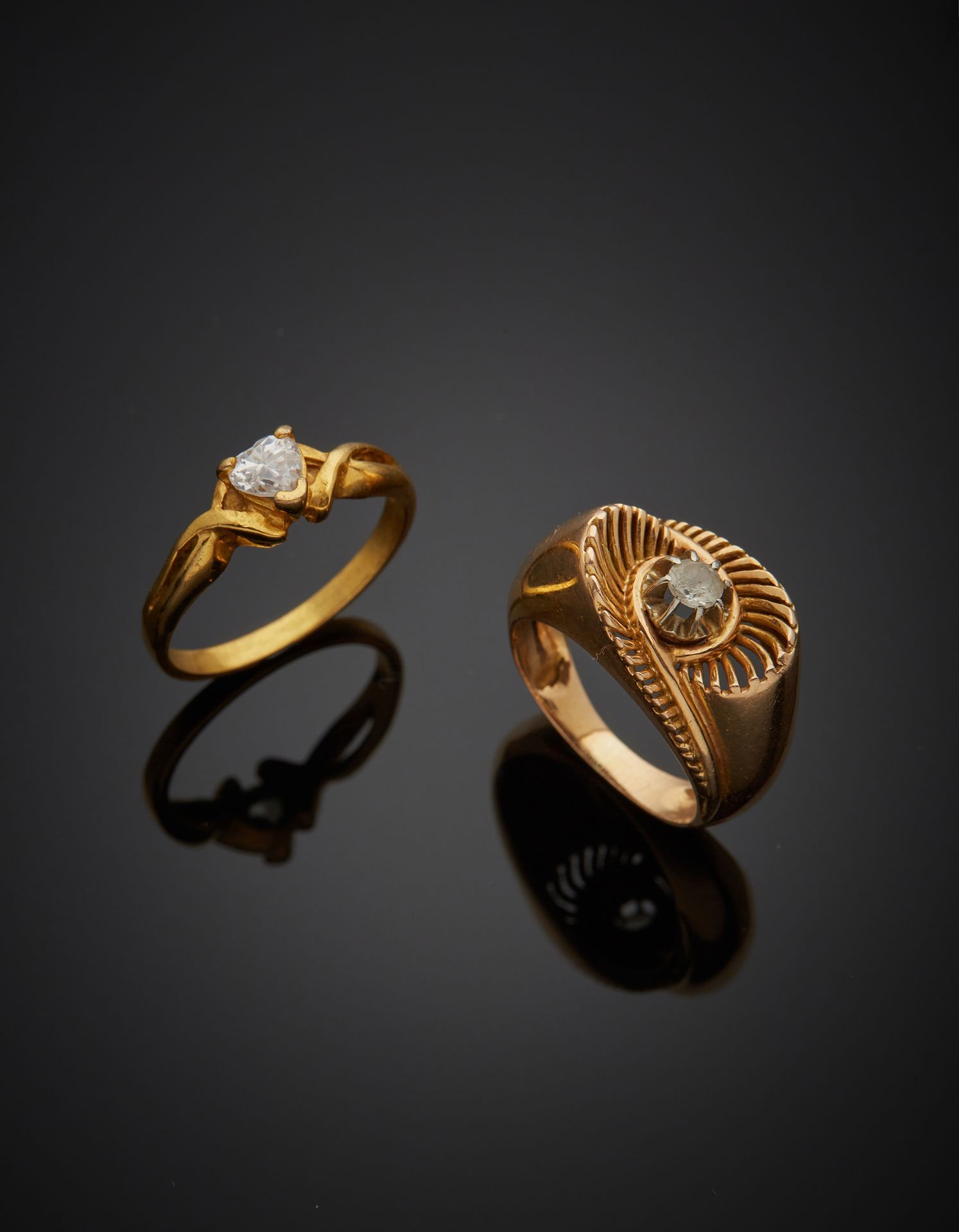 Null 拍品包括一枚18K黄金750‰的戒指和一枚金属戒指，镶嵌有白色宝石，其中一颗是心形的。事故、遗失和使用的痕迹。

手指尺寸52和54 金戒指的总重量6&hellip;