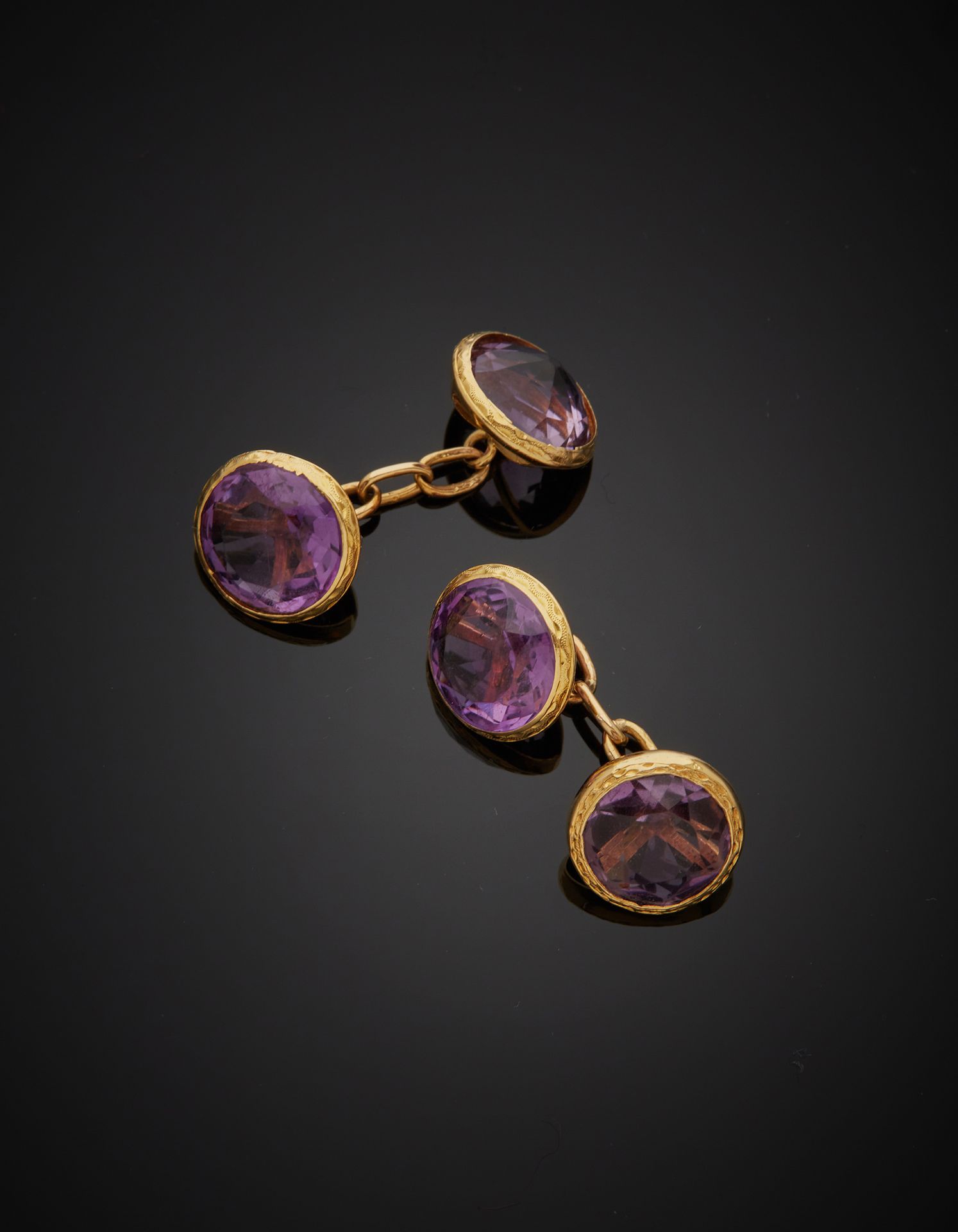 Null 一对18K黄金750‰的双袖扣，镶嵌着圆形的紫罗兰宝石（其中一个镶嵌在背面）。凹痕和金光闪闪的石头。

毛重9.40克