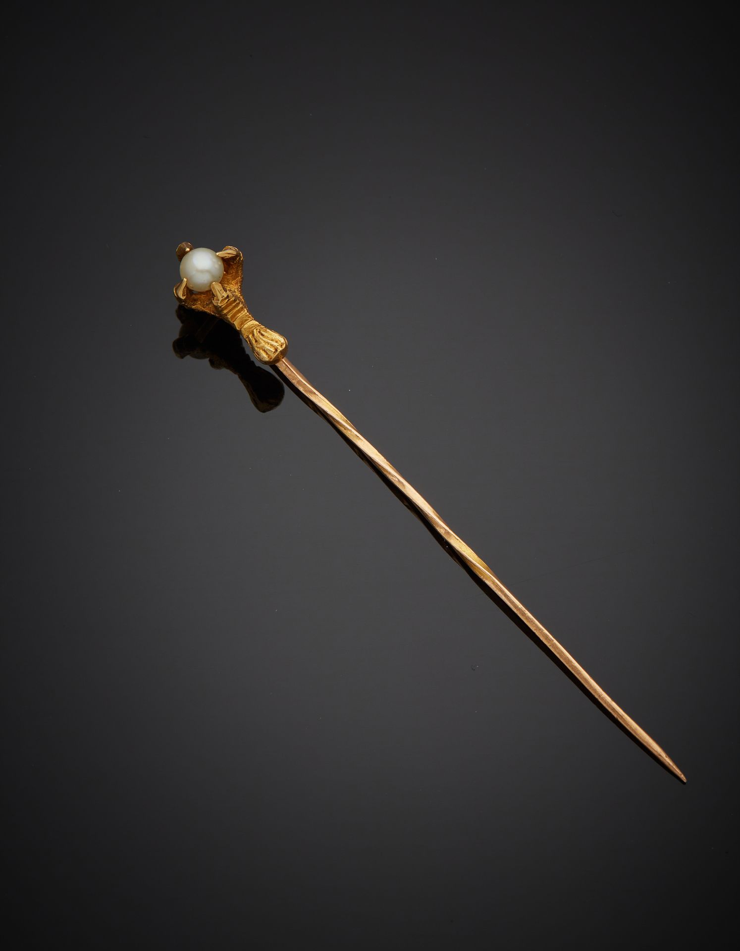 Null 一枚18K黄金750‰的领带别针，上面装饰着一只手持养殖珍珠的雄鹰的温室。穿到珍珠上。

H.6.30 cm 毛重 2.20 g