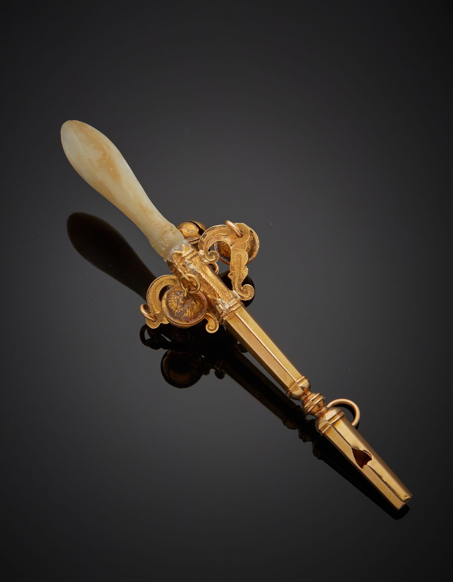 Null 一个18K黄金750‰的拨浪鼓，装饰有四个铃铛，装有珍珠母口罩，反对哨子。法国作品，19世纪末。磨损和缺乏珍珠母，轻微修复和轻微变形。

长10,30&hellip;