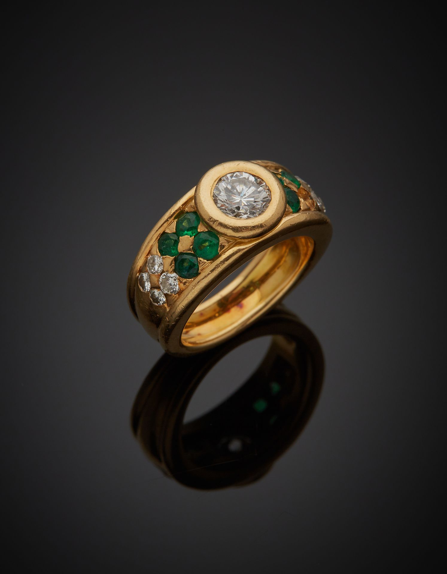 Null 一枚18K黄金750‰的戒指，中央镶嵌着一颗明亮式切割钻石，肩部镶嵌着绿色宝石和明亮式切割钻石。缺少一块石头，有碎裂和破损的石头，有轻微变形。

手指&hellip;
