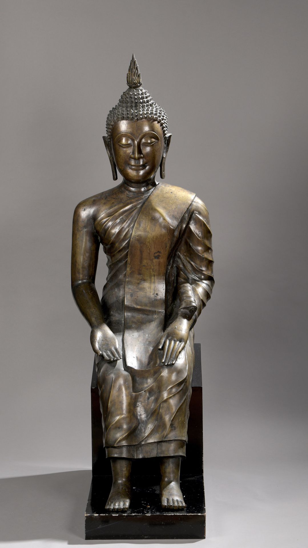 Null 一尊坐着的佛陀铜合金雕像，双手握着布米斯帕尔卡（bhumisparça mudra），身穿僧袍，头戴火焰乌尼沙，头发卷曲。黑色漆面的木质底座。ushn&hellip;