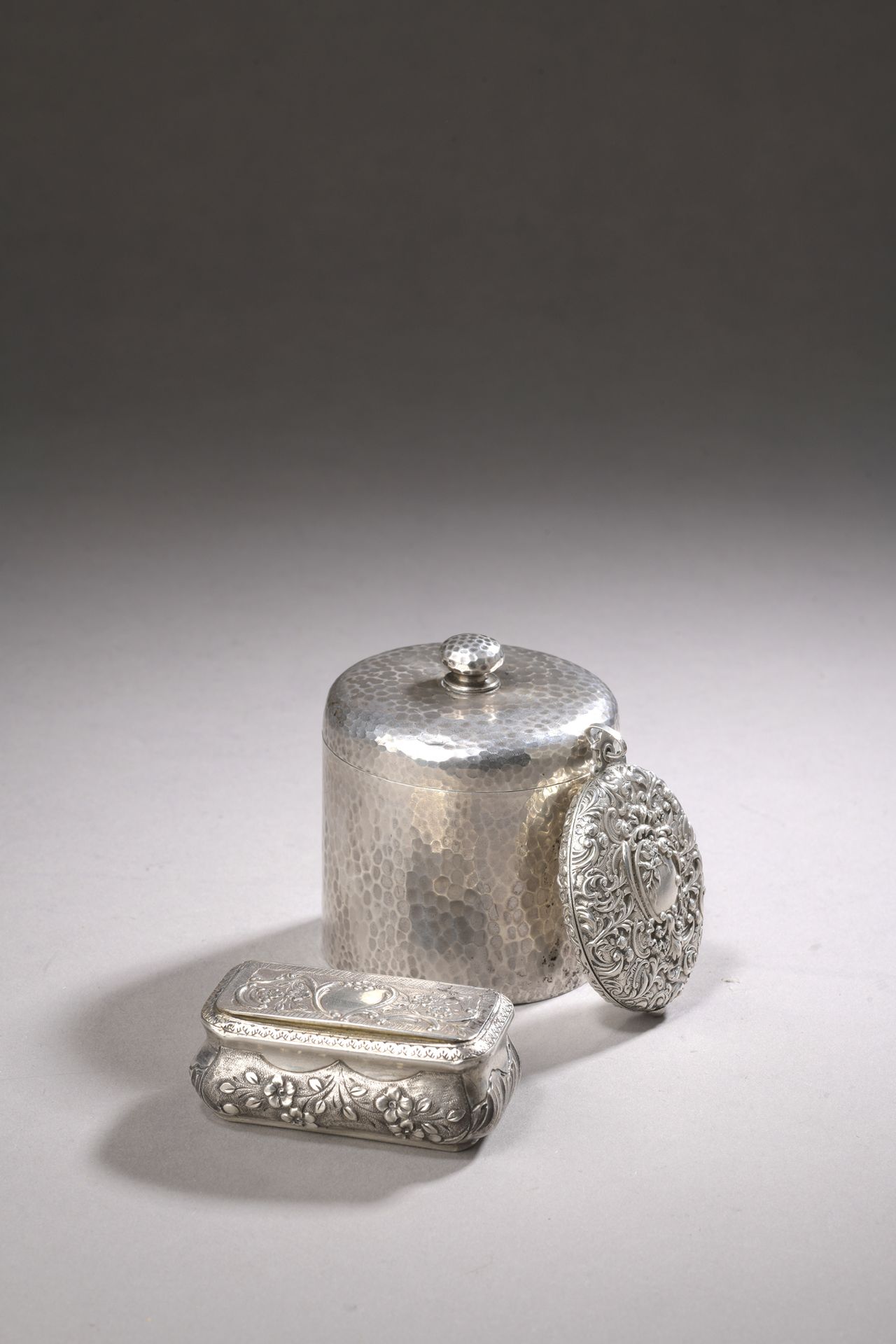 Null 一个银质茶盒，第2个标题为800‰，圆柱形，锤击而成。附有一个银质鼻烟盒，标题为950‰玑镂，以及一个银质吊坠，标题为950‰，上面有卷轴。

毛重2&hellip;