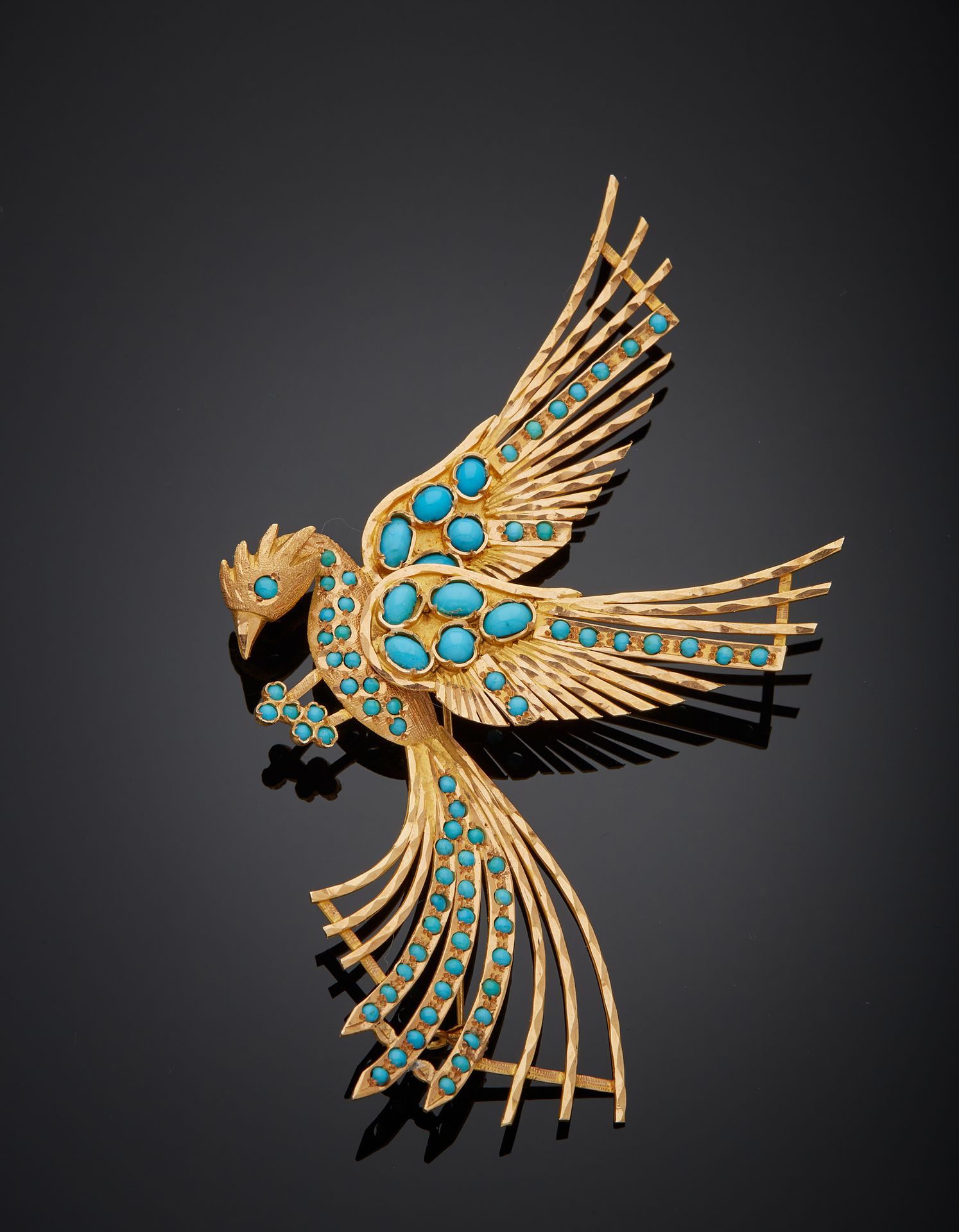 Null 一枚18K黄金750‰胸针，呈鸟形，展开的翅膀上装饰着凸圆形切割的绿松石。

高度约12厘米 毛重26.30克