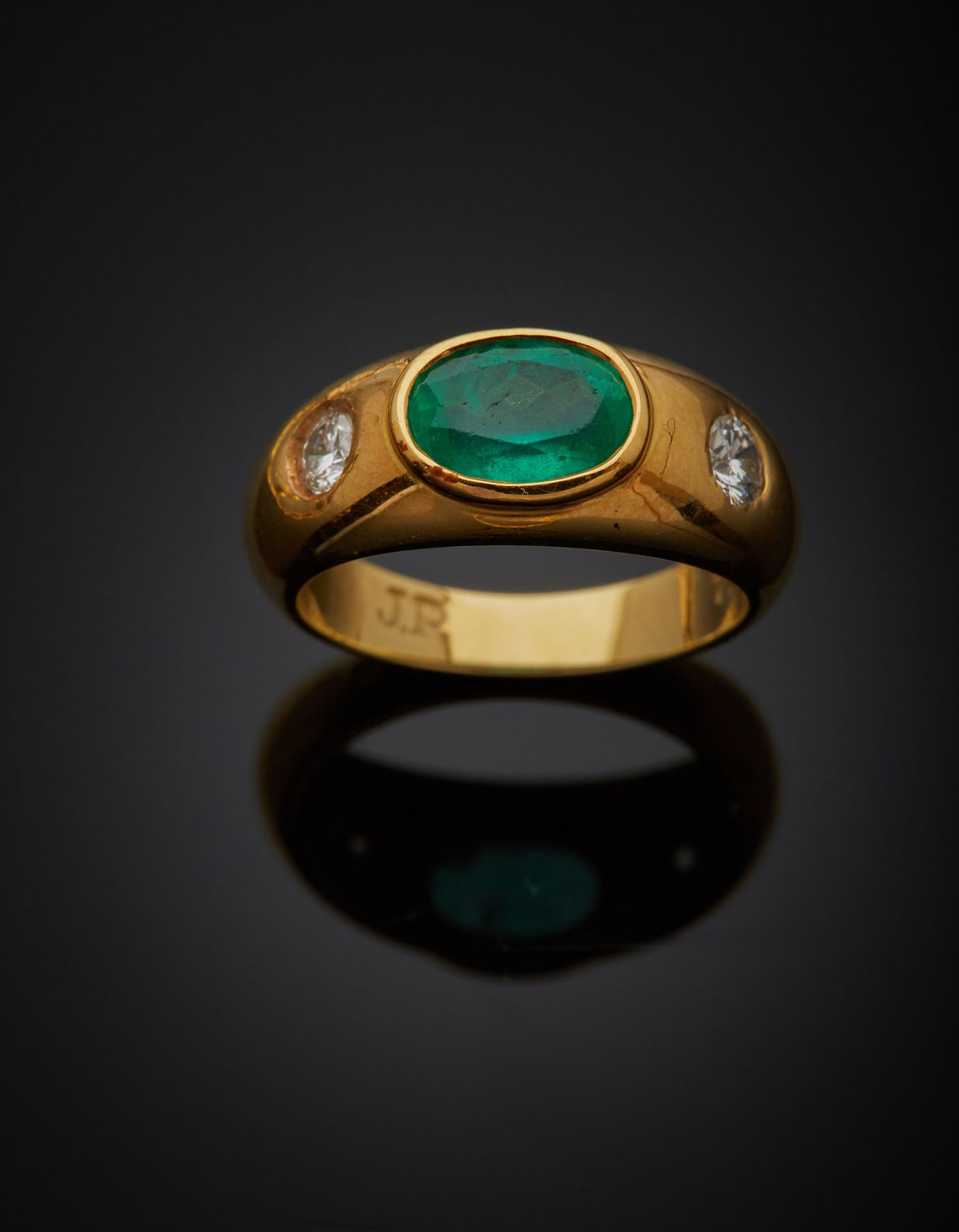 Null 一枚18K黄金750‰带状戒指，中央刻有椭圆形的绿色宝石，肩部镶有明亮式切割钻石。石头有缺口，略微变形。

手指尺寸48 毛重5.10克