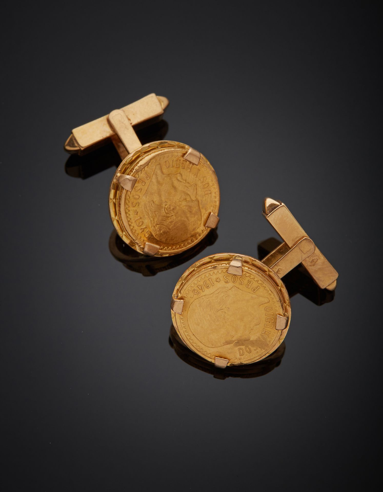 Null 一对18K黄金750‰的袖扣，装饰有两枚半比索的硬币，弹簧棒系统。

图案直径1.70厘米 毛重11.80克