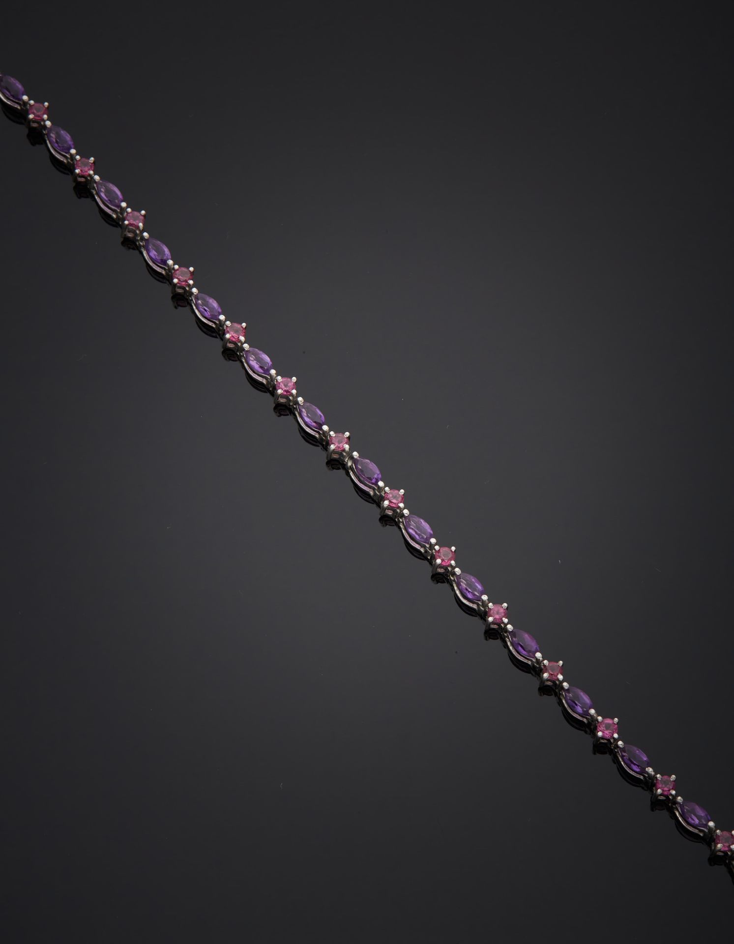 Null 一条18K白金750‰的手链，衔接并镶有脐带形紫罗兰宝石和圆形粉红宝石。棘轮扣有八个保险。法国作品。有使用过的痕迹。装在一个箱子里，还有它的对箱（污渍&hellip;