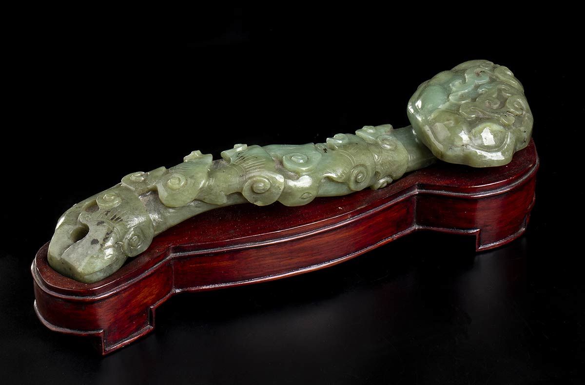 Null 绿玉如意瓶
中国，19-20世纪

外表有灵芝菌的浮雕装饰，木质底座。

25厘米