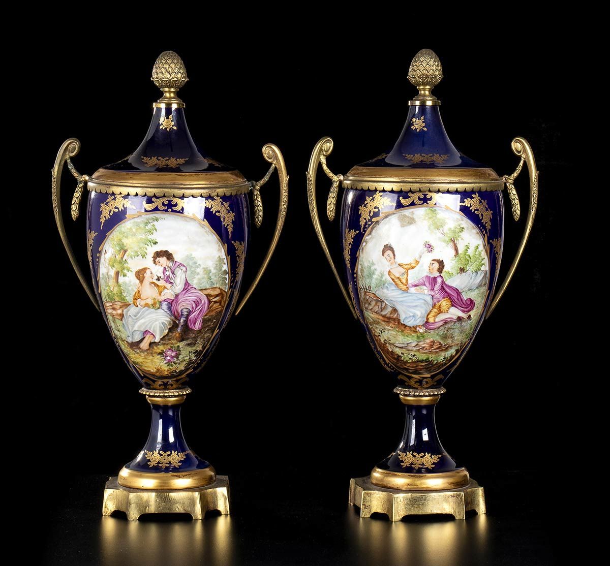 Null SÈVRES（风格）

一对陶罐，XX世纪
瓷器，高44厘米
一对蓝瓷陶罐，椭圆形的中心装饰着英勇的场景，安装在青铜器上，Sevres风格。
底下有 &hellip;