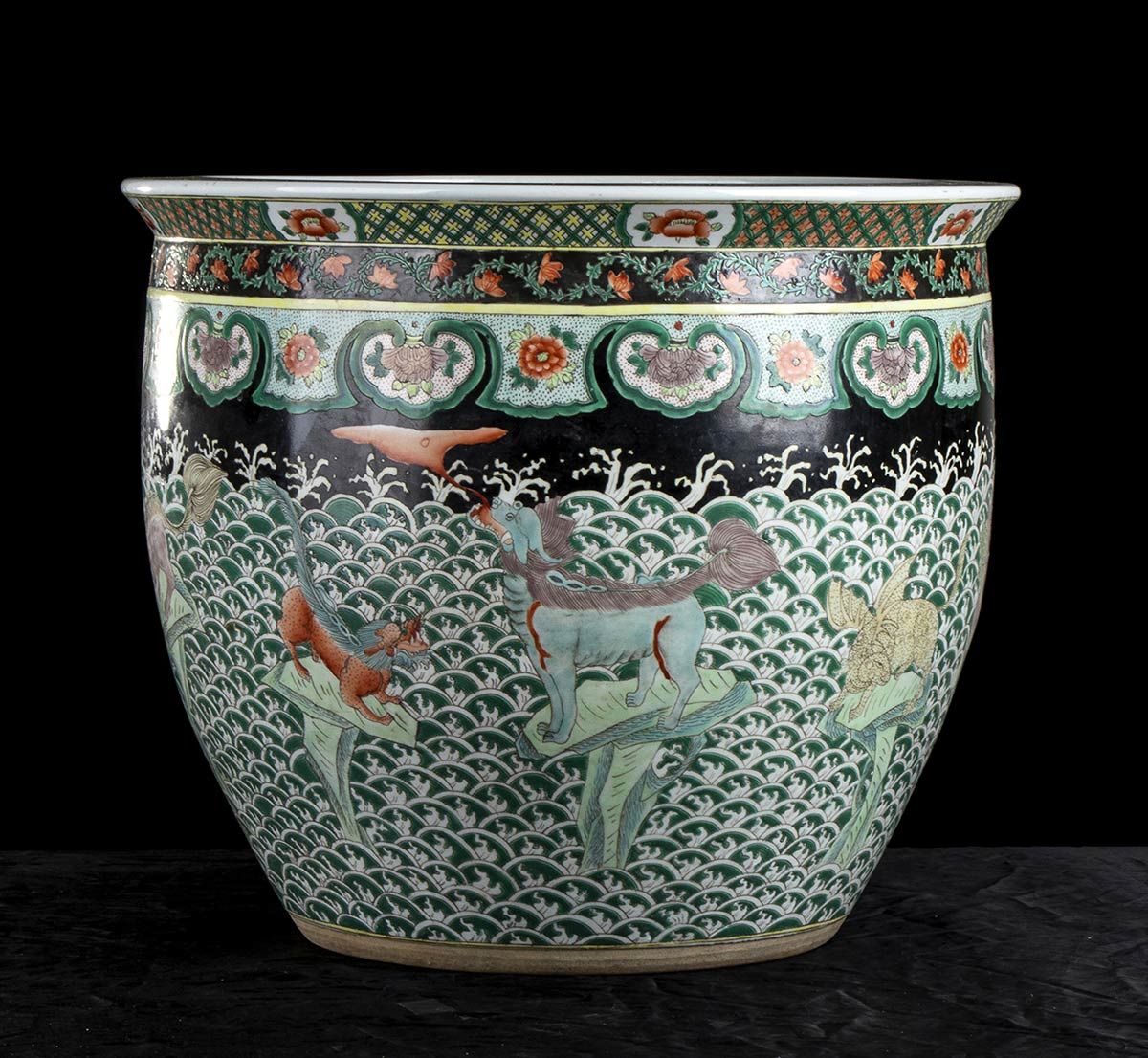 Null 一个彩绘陶瓷罐
中国，20世纪

圆形截面，外表面有黑底多色装饰，上半部分是花卉和几何图案，下半部分是海浪中的奇妙动物。

46 x 39厘米