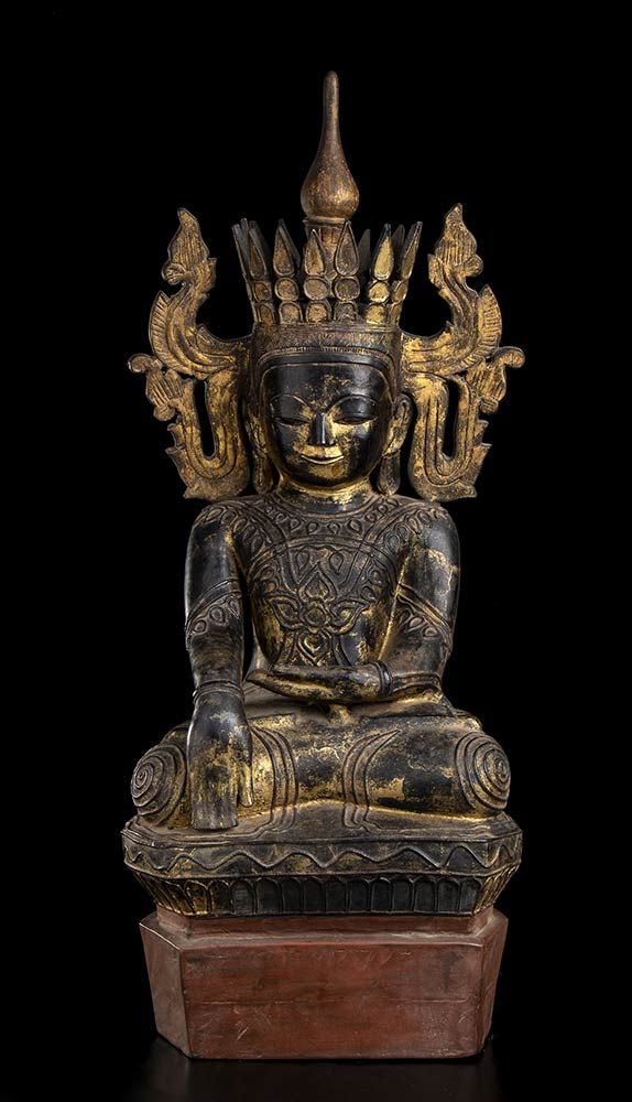 Null 一件带鳞片和镀金的木制坐姿佛像
缅甸，掸族风格，19-20世纪

人物盘腿坐在一个有形状的基座上，右臂沿侧面伸展，手指朝下做 "触地 "的手势（bhu&hellip;