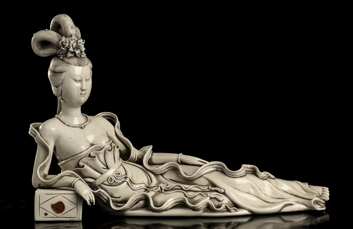 A 'BLANC DE CHINE' PORCELAIN RECUMBENT GUANYIN 瓷器 "白玉兰 "观音菩萨坐像

中国，20世纪

两个凹陷的标记&hellip;