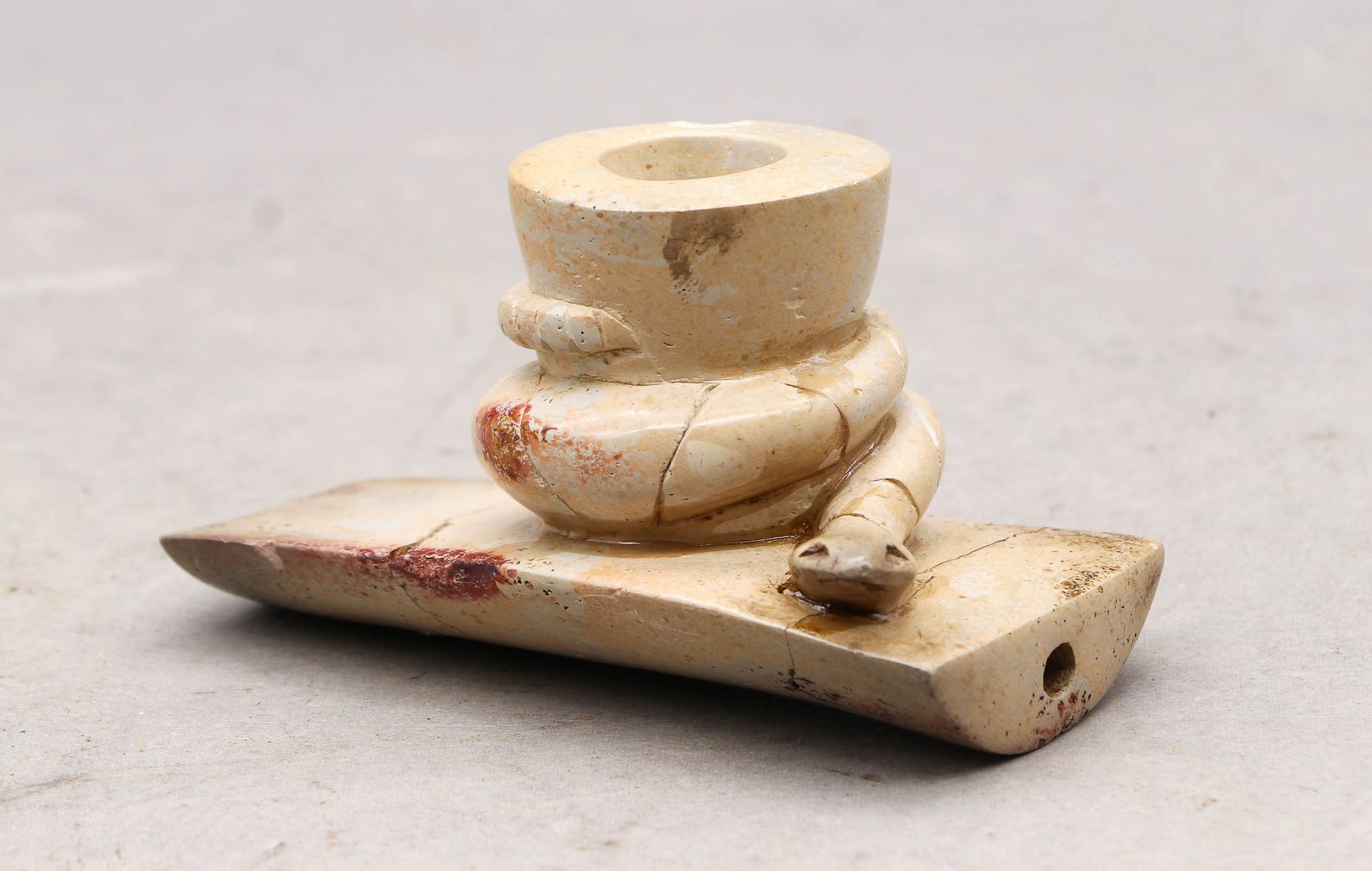 Null 雕刻的石管碗。霍普韦尔文化（？），美国。高：5；宽：8厘米（事故和重粘）。注意：这种烟斗让人联想到古时筑丘者文化的霍普韦尔风格。它显示了一条盘绕着自己&hellip;