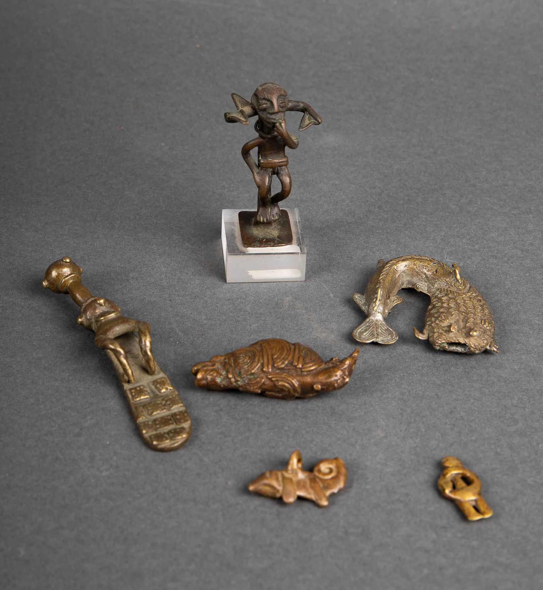 Null 加纳的一套四件阿散蒂雕像砝码；科特迪瓦共和国Sénoufo的一个拟人护身符；洛比的一个变色龙吊坠。青铜材质，带有古老的铜锈。20世纪初。长：8.5；5&hellip;