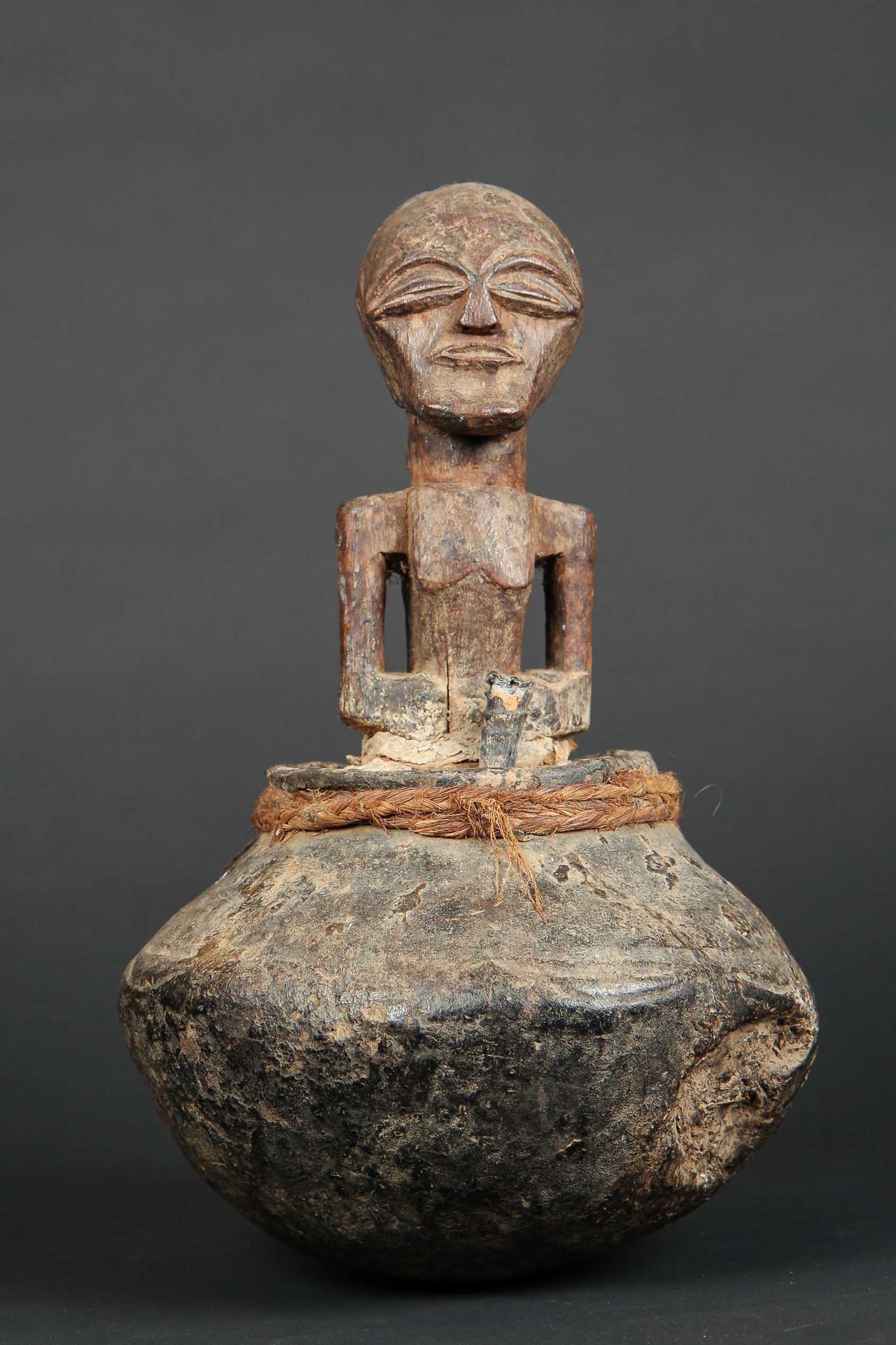 Null 用木头、赤土、植物纤维和各种预防材料制成的占卜壶。它呈现了一个具有美丽保护表情的祖先形象。松耶，刚果民主共和国，20世纪。高：33厘米。出处：前私人收&hellip;