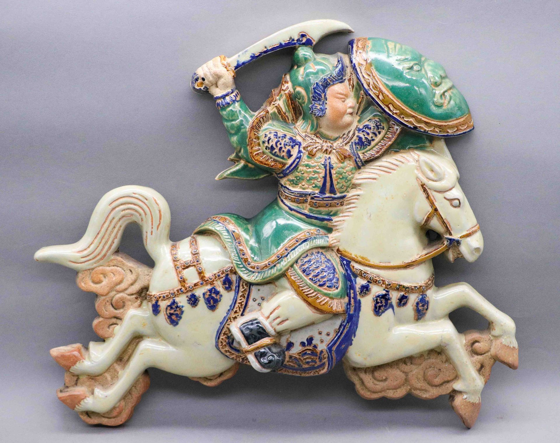 Null 一个多色釉米色陶器壁灯，描绘了Phù Đổng Thiên Vương将军，一个骑着白马驰骋的传奇少年英雄。它的背面有一个压印的标记。越南，Biên &hellip;