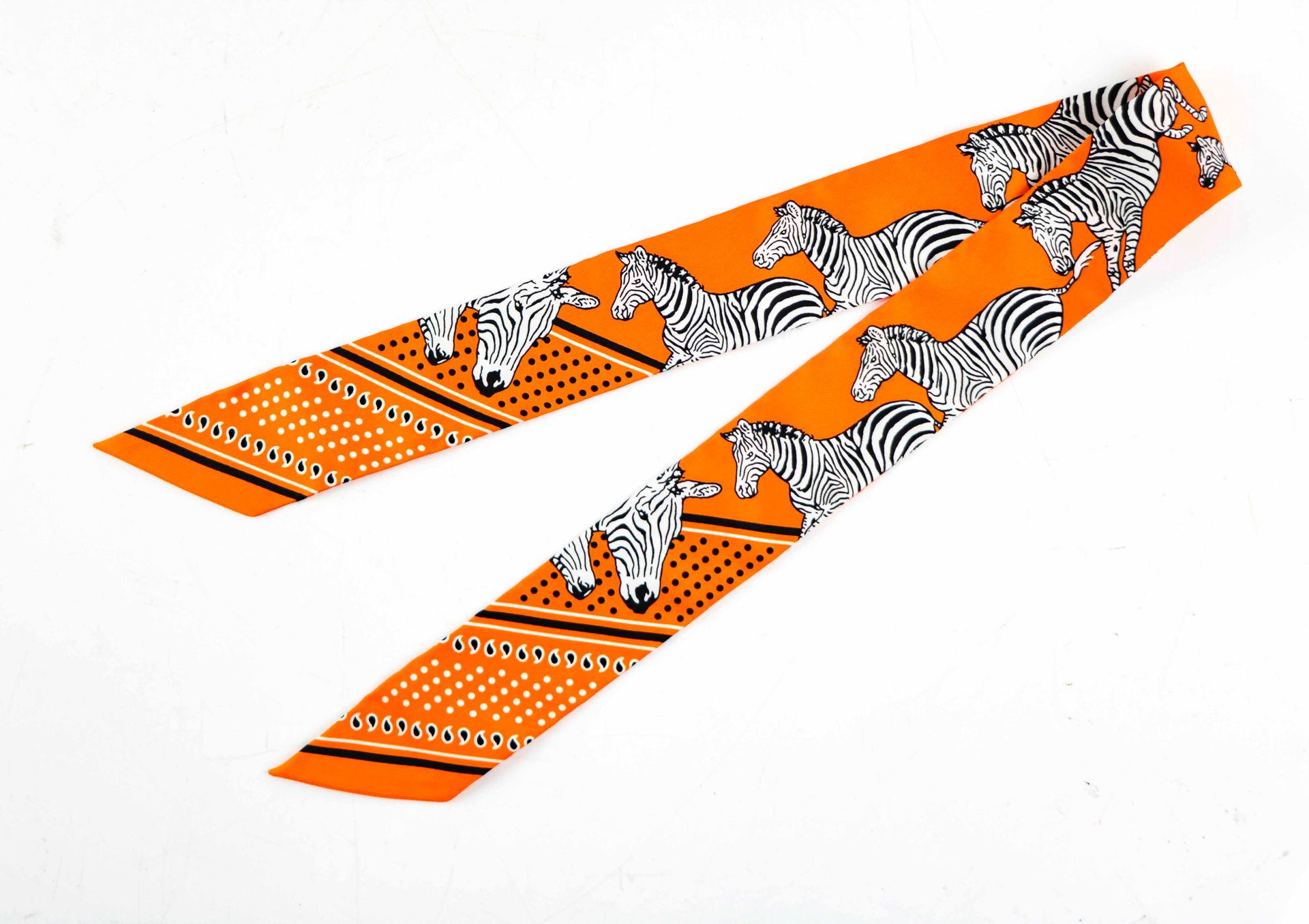 Null HERMES. Twilly aus mehrfarbiger Seide mit Zebra-Dekor auf orangefarbenem Gr&hellip;