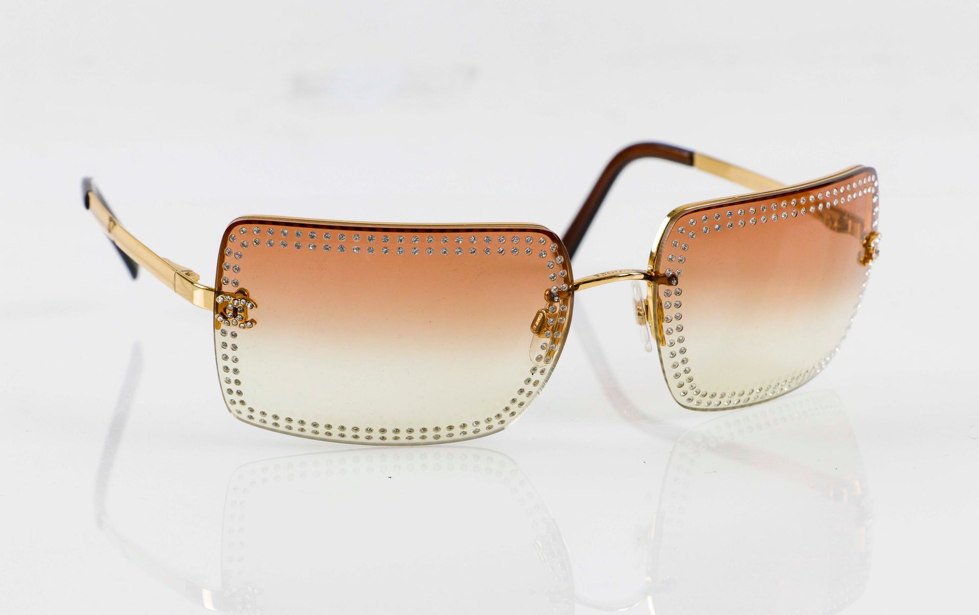 Null CHANEL. Pair of gold rhinestone sunglasses. In its case