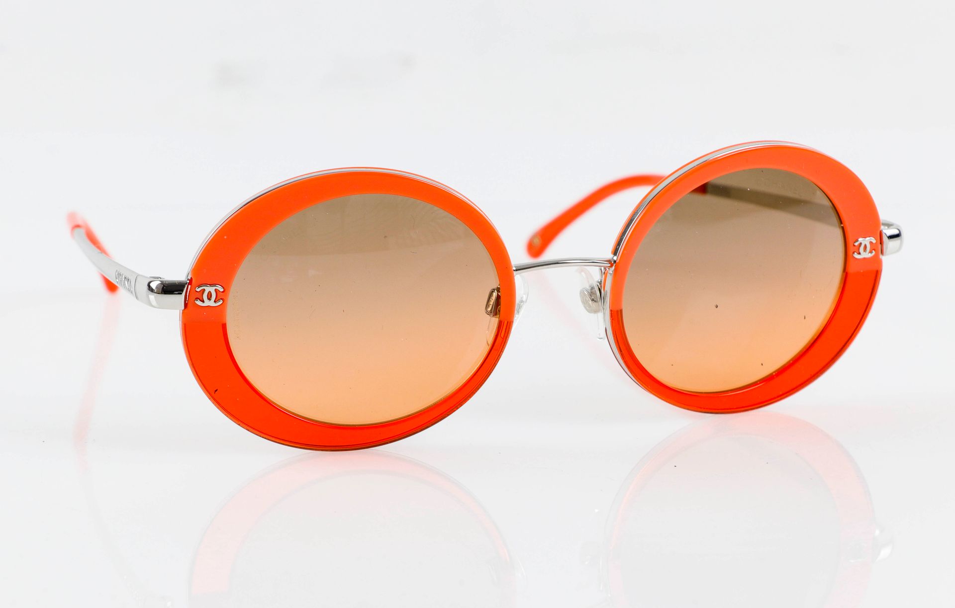Null CHANEL. Ein Paar orangefarbene Sonnenbrillen. In ihrem Etui