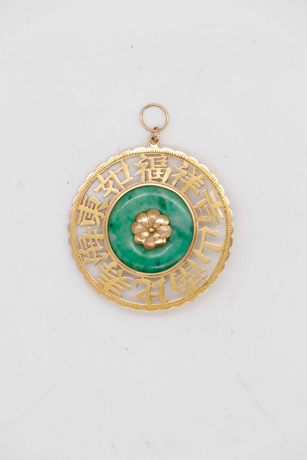 Null Pendentif assiatique en or centré d'un disque de jade. Poids brut : 13,1 g