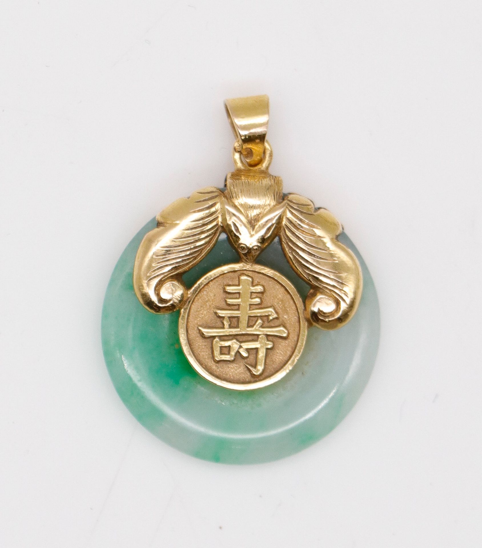 Null Pendentif asiatique en or centré d'un disque de jade. Poids brut : 6,3 g