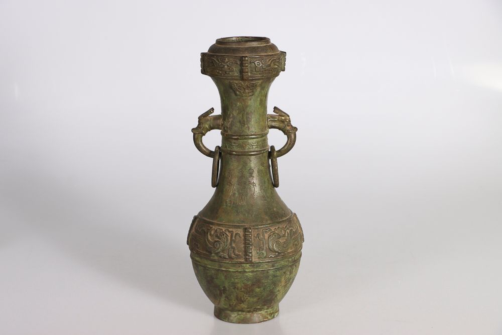 Null 中国，19世纪。古代风格的铜瓶，瓶身饰有纹身面具楣，肩部有古代铭文，两侧有两个带活动环的变格把手。高：41.5；深：18厘米（穿孔）。