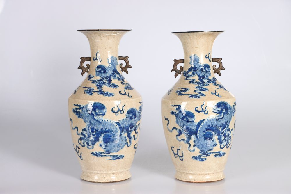 Null (2) 中国，19世纪。一对南京瓷器花瓶，阳台形式，在裂纹的米色地面上用钴蓝装饰云中的嵌合体，两边有两个造型的把手。底部有 "顺治 "四字款。高：42&hellip;