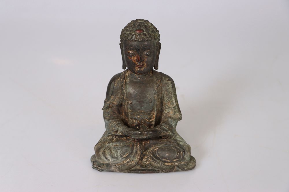 Null 中国，明朝时期。青铜佛像，以前是涂漆和镀金的。他是坐着的，胸前有一个卐字形。重量：约1700克。高：19厘米（磨损）