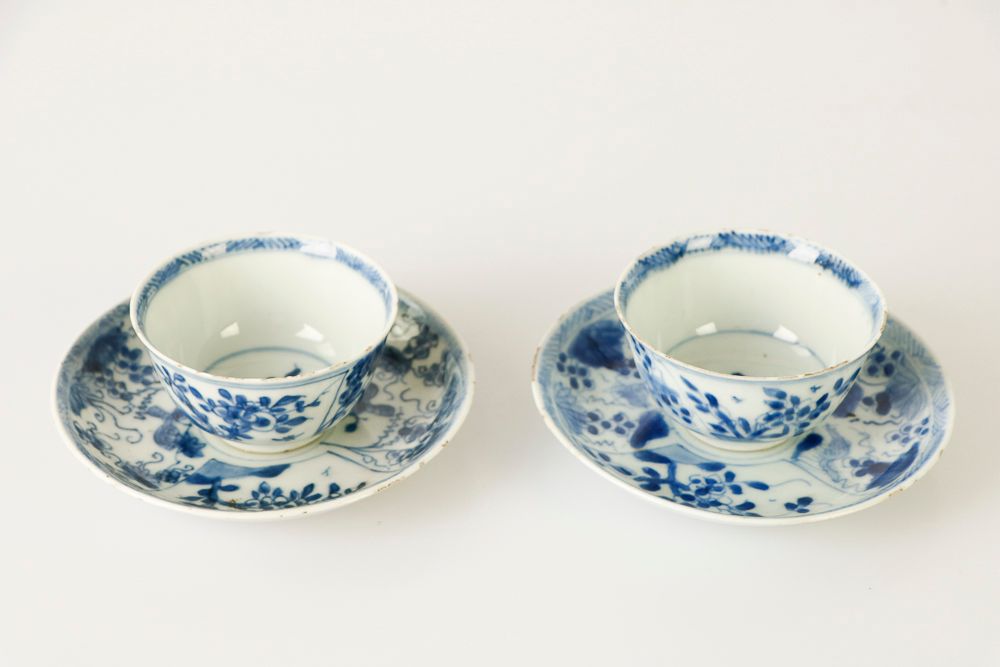 Null (2) 中国，康熙时期，用于出口。一对青花瓷杯和碟子，上面有花纹和藤蔓上的小虫。杯子：高：4；直径：7.3厘米。碟子。D: 11.7 cm (有缺口)