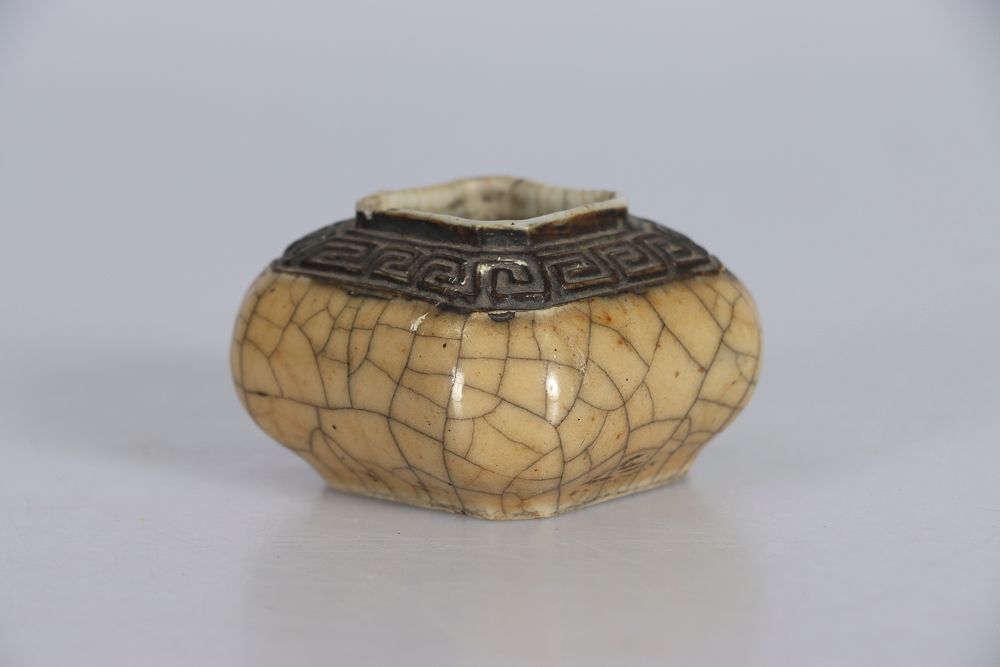 Null 中国，南京，19世纪。一个小的四角形奶油色裂纹瓷水壶，底座下有成化款。高：4；宽：6,5；深：6,5厘米（颈部有小意外）。