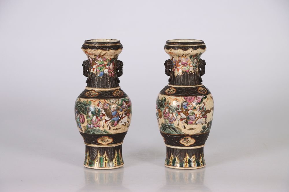 Null (2) 中国，19世纪。一对南京的花瓶，在奶油色的裂纹地上用多色珐琅彩装饰战争场景。高：26,5厘米（每个）