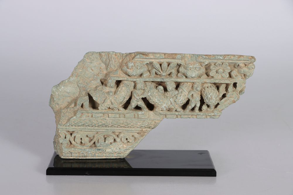 Null 印度，犍陀罗地区，1-5世纪。灰色片岩浮雕，表现的是中央部分拿着花环的普提、叶子、变形的头和花的装饰。安装在一个底座上。高：18.5；宽：32厘米