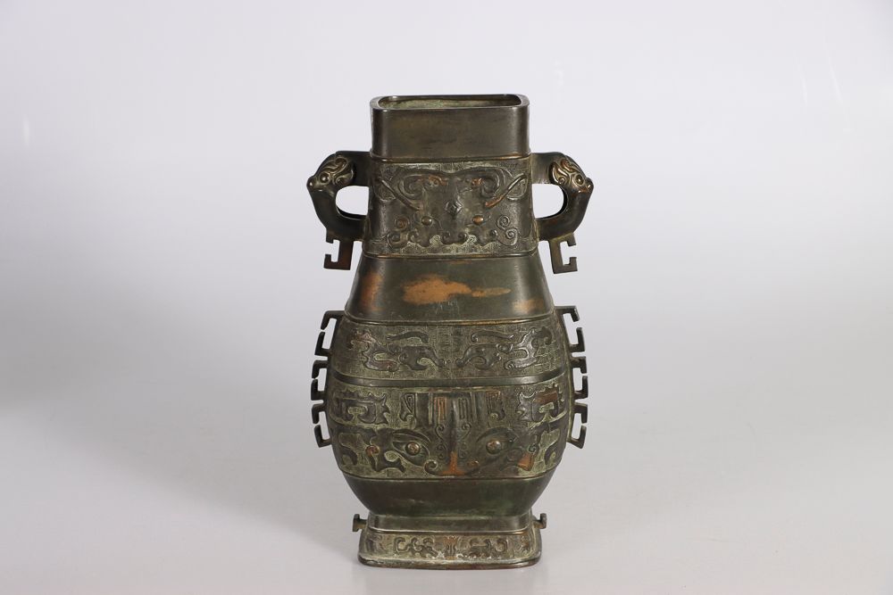 Null 中国，19世纪。古代风格的方湖大铜瓶，有饕餮面具的浮雕装饰，两个变异的把手。高：37；宽：23厘米（磨损）。