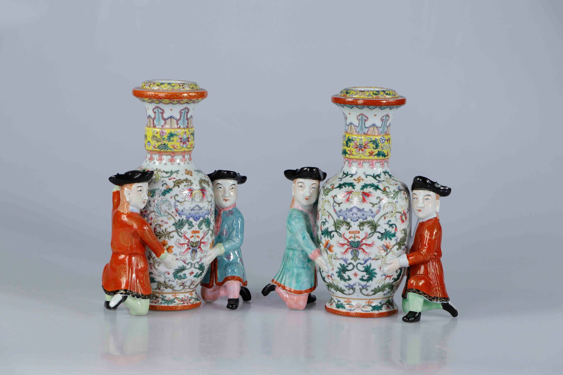 Null (2) 中国，20世纪。有趣的一对瓷器花瓶。阳台形的花瓶用粉彩装饰着蝙蝠和叶子，每个花瓶由两个跪着的陌生人支撑着，穿着有特色的衣服。高：24厘米（每个&hellip;