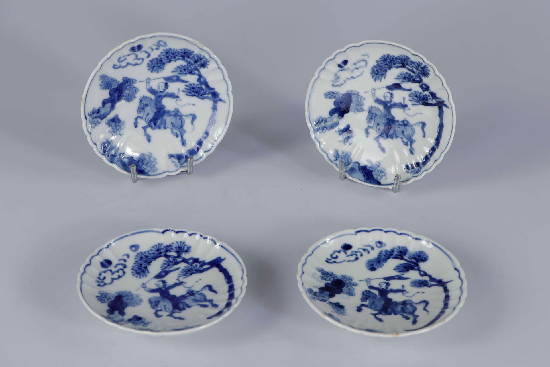Null (4) 中国，18世纪。一套四只圆瓷碗，多棱边，白底钴蓝装饰，松树下有骑手。直径：12.5厘米（每个）（边缘有缺口和小的修复）。
出处：私人收藏，瑞士&hellip;
