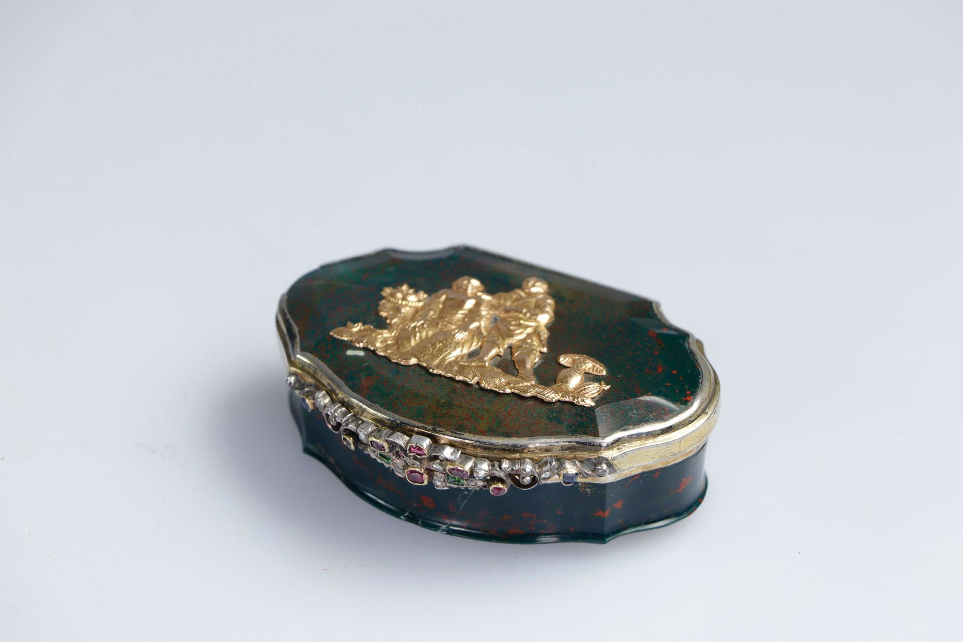 Null 18世纪。血碧玉和青铜的轮廓盒，扣子上镶嵌着钻石、绿宝石、红宝石和蓝宝石，顶部装饰着代表中国夫妇英勇场景的黄金图案。可能是一份外交礼物。毛重：约74.&hellip;