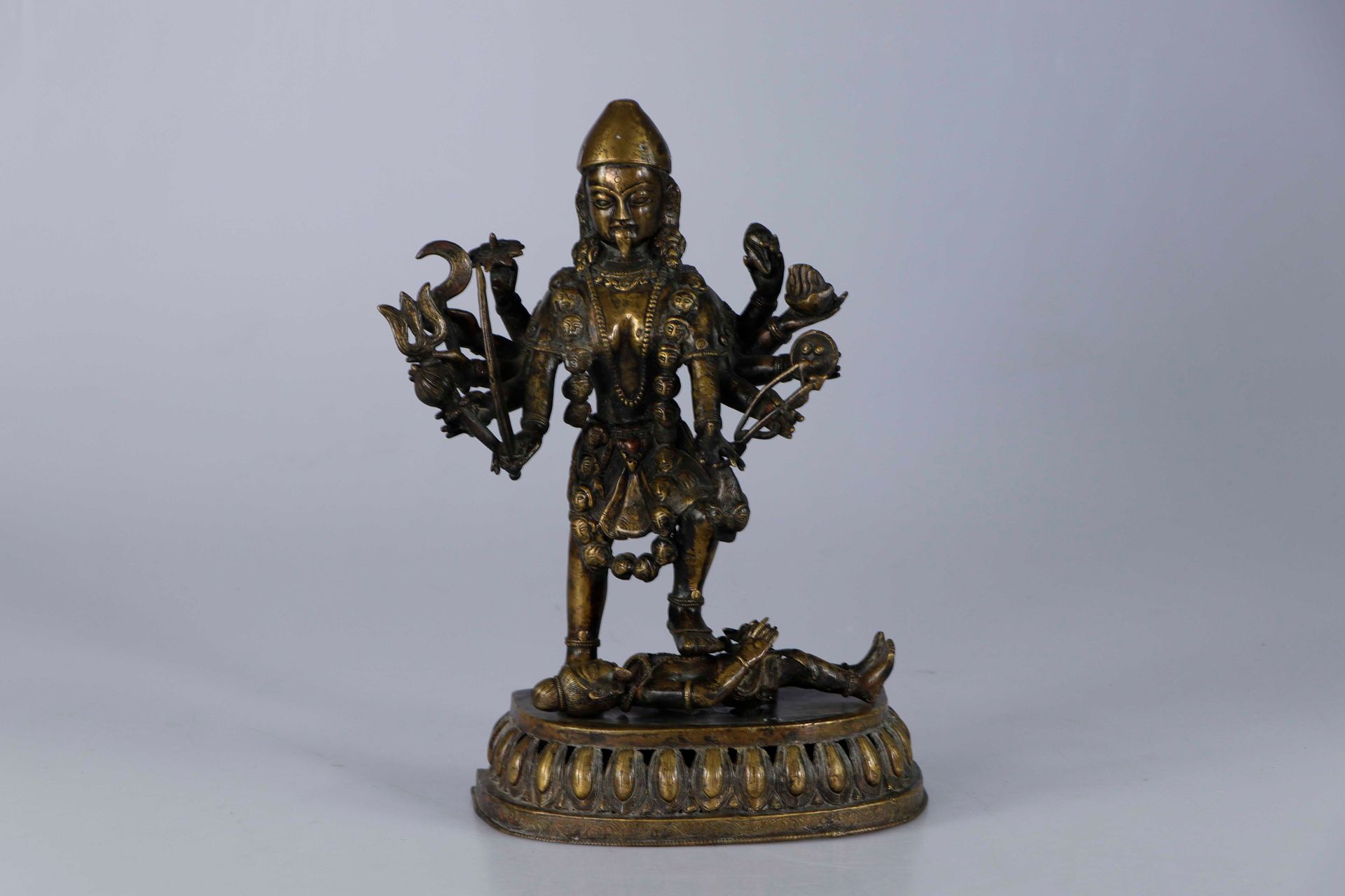 Null 尼泊尔，19世纪。代表十臂神卡利的青铜组，站在莲花形底座上，用一只脚击倒敌人。她的脸是威胁性的，她的舌头伸出来，她的十只手拿着各种武器和属性，她的项链&hellip;