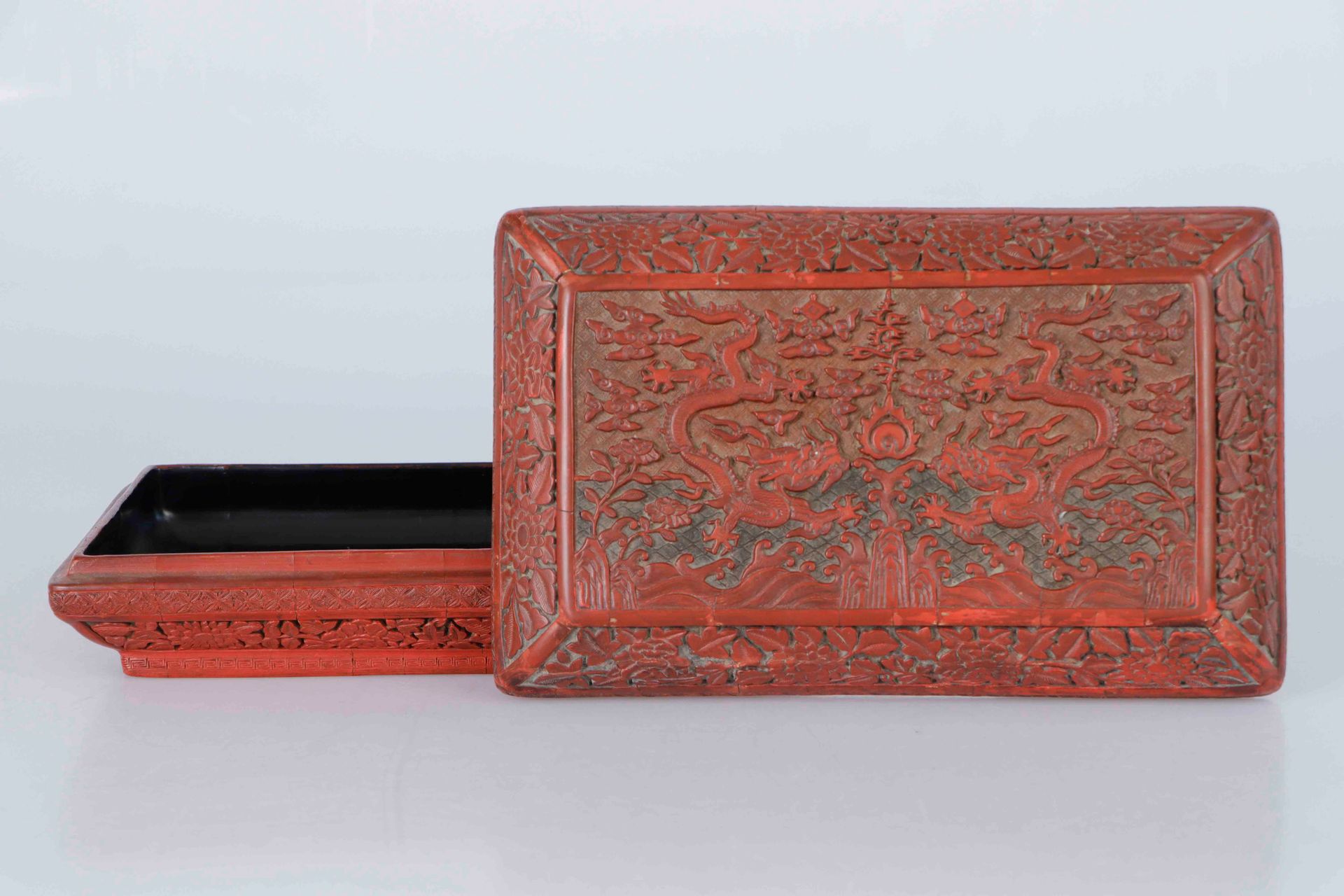Null 中国，明朝，万历年间（1573-1619）。非常罕见和重要的三色漆盒。长方形，略带圆角，盖子上有非常精细的浮雕装饰，在黑色和赭色的背景上，有两条五爪龙&hellip;