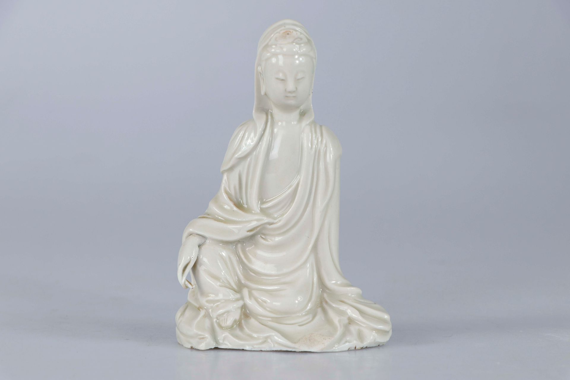 Null 中国，17-18世纪。德化观音的瓷器雕像。她坐在岩石上，身穿柔软的褶皱长袍，面容安详。高：14厘米（小碎片，小烧制缺陷）。出处：Georges PAL&hellip;