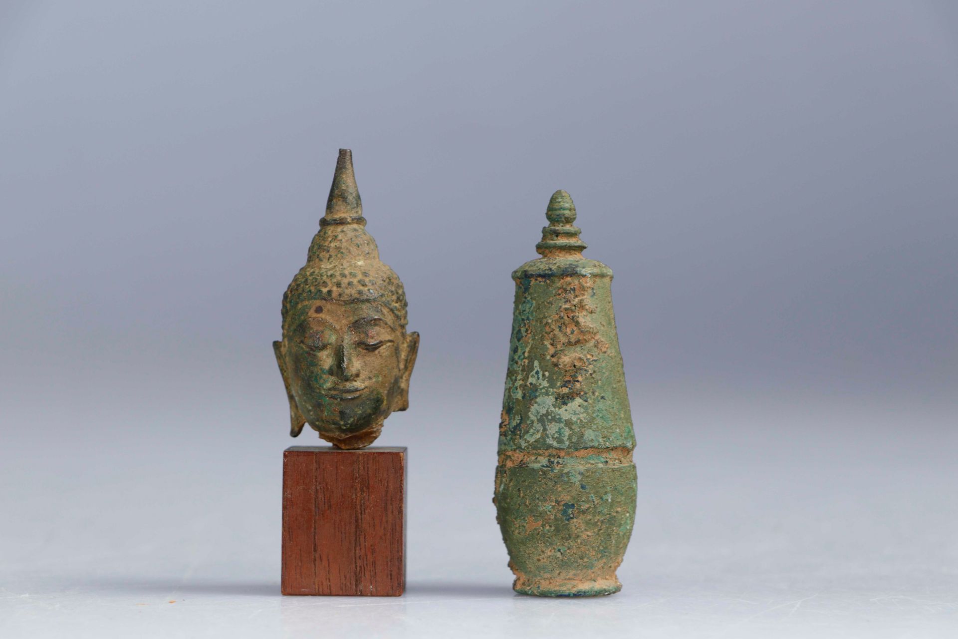 Null (2) SIAM，17-18世纪和CAMBODIA，高棉艺术。铜制佛头碎片，有出土的铜锈。高：6厘米（不包括底座）。附带一个有挖掘出的青铜槟榔壶。高：&hellip;