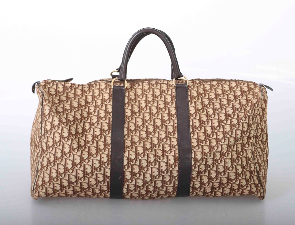 Null 克里斯蒂安-迪奥。帆布和巧克力色皮革的旅行包。拉链封口，带拉链口袋（意外）。镀金金属首饰。长：55厘米