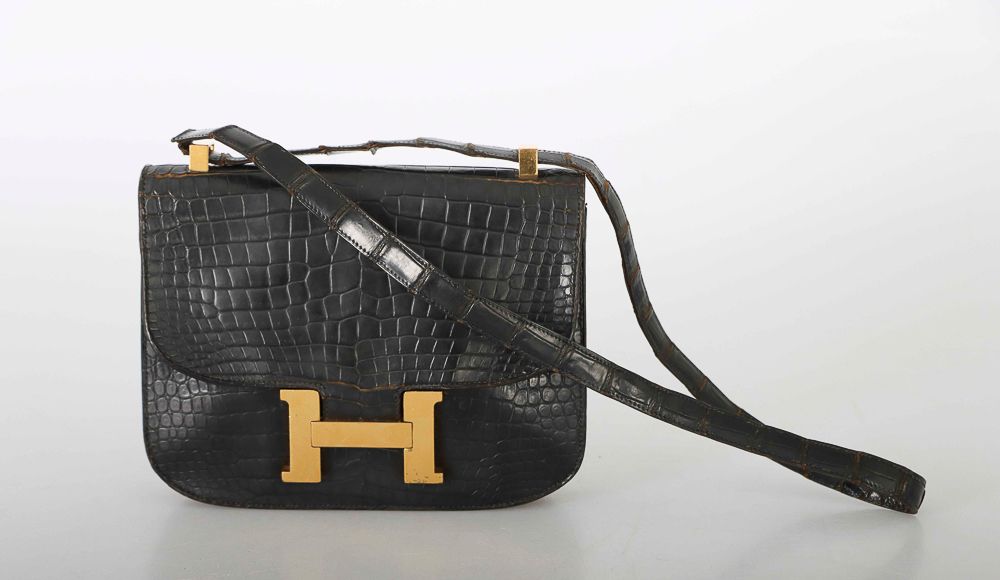 Null HERMES巴黎。约60年代。黑色鳄鱼皮 "Constance "包。鍍金飾品。内部有一个贴袋和一个带拉链的口袋。翻盖开合，有一个 "H "的扣合应用&hellip;