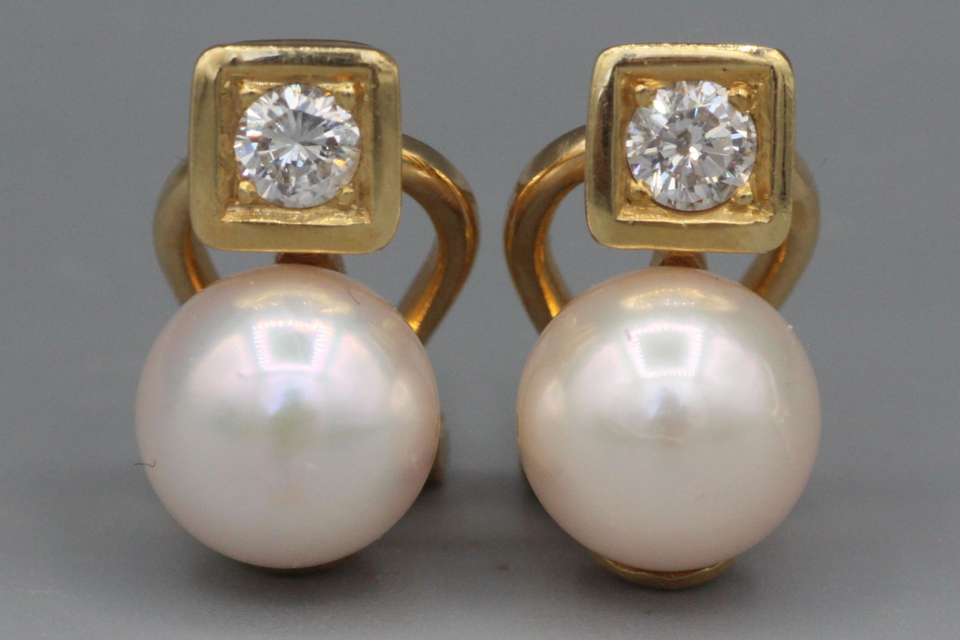 Null Paar Goldohrringe mit einem Diamanten und einer Perle. P. 7,7g