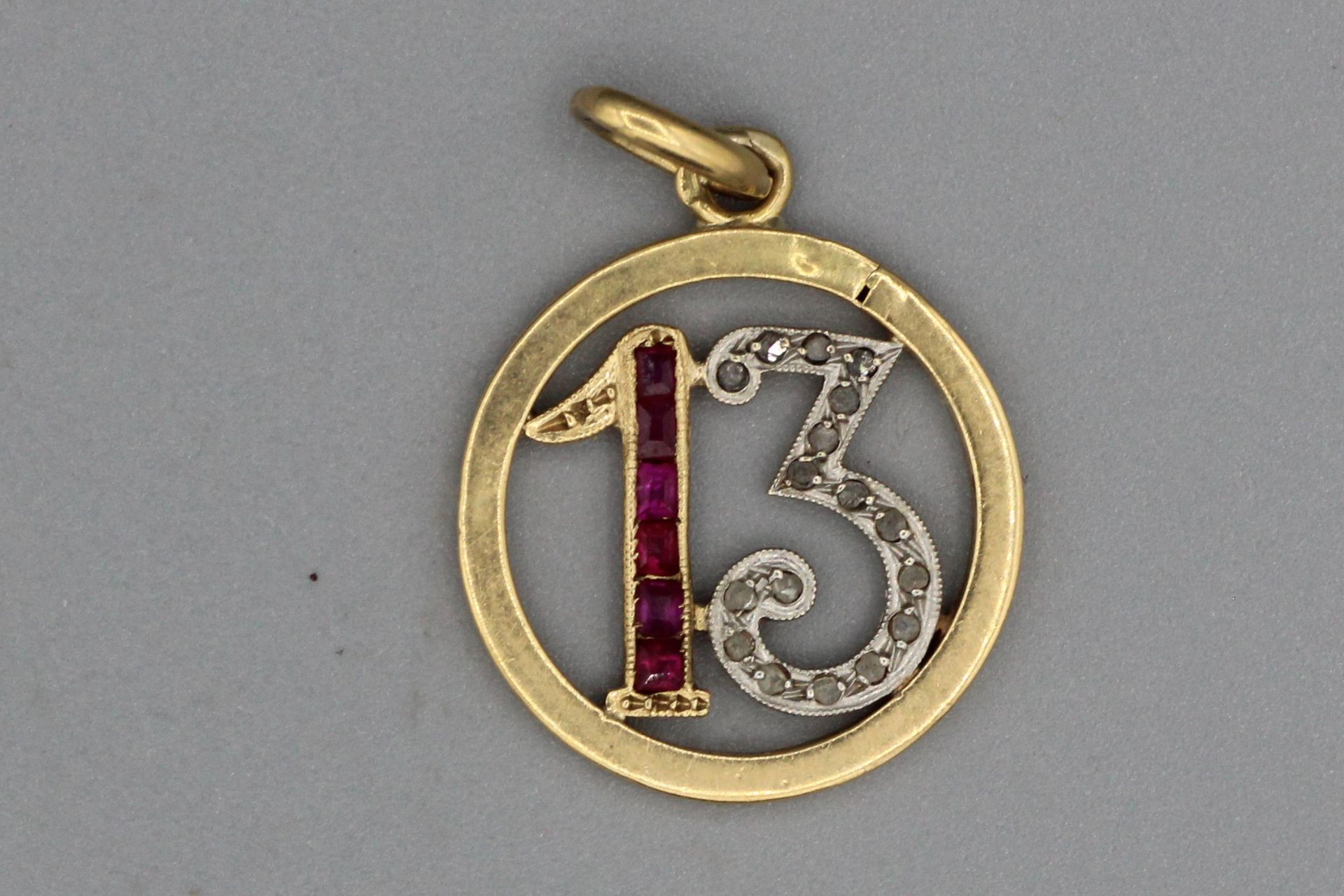 Null Pendentif « 13 « en or serti de rubis calibrés et de diamants. P2,1g