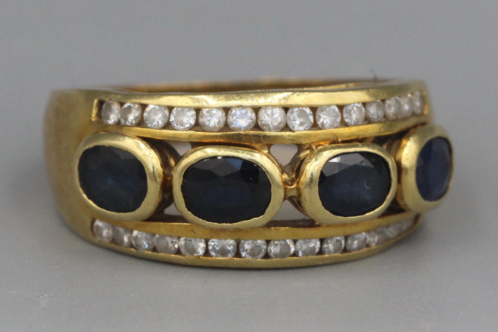 Null Gold ring set with four sapphires surrounded by lines of diamonds. P. 5.2g