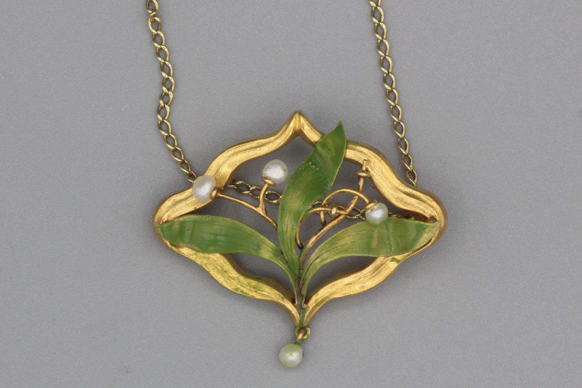 Null Collier en or orné d’un motif 1900 en or émaillé enrichi de perles. P. 4,8g